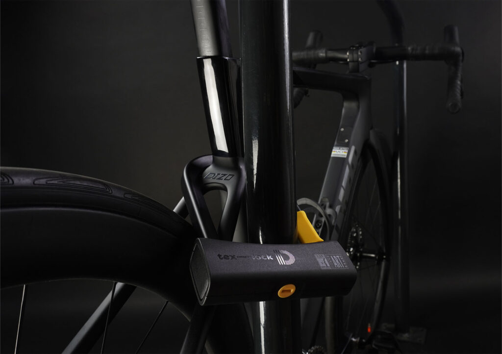 D-lock Bügelschloss sichert Fahrrad an Sattelstange mit Fahrradständer