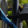 D-lock Bügelschloss sichert Sattelstange und Sattelstrebe mit Textilseil in Farbe morpho blue am Fahrradständer