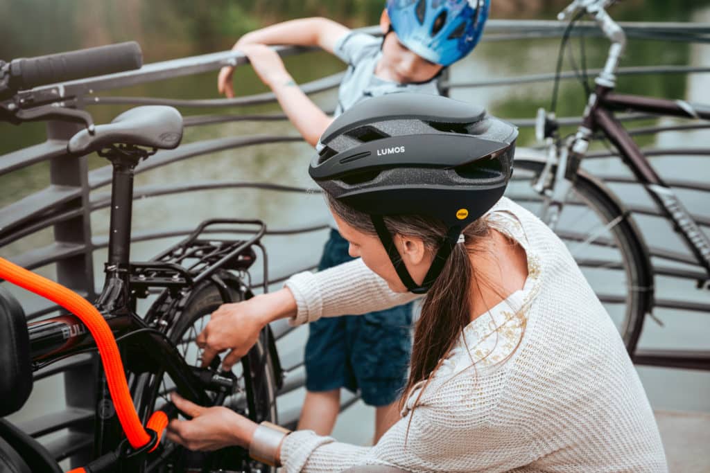Mutter mit Kind schließt Fahrrad mit tex-lock eyelet an
