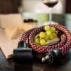 tex–lock orbit in chateau red liegt zusammen gewickelt um Weintrauben-Dolde mit Käse und Wein im Hintergrund