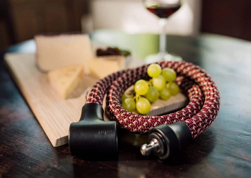 tex–lock orbit in chateau red liegt zusammen gewickelt um Weintrauben-Dolde mit Käse und Wein im Hintergrund