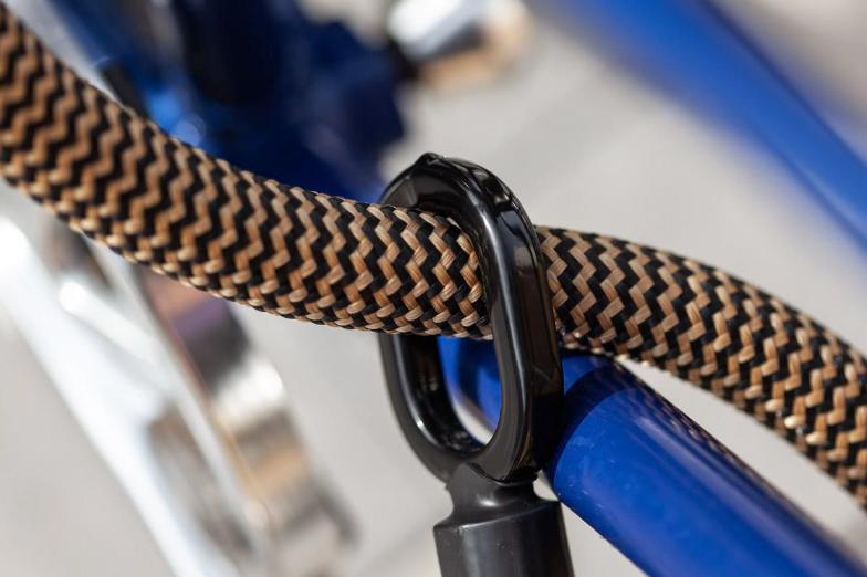 Tex-lock eyelet gold umschließt per Loop-Through-Prinzip blauen Fahrradrahmen
