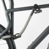 Hinterrad und Oberrohr vom Fahrrad mit Bügelschloss und Verlängerung aus Textil in grau-schwarz am Fahrradständer angeschlossen