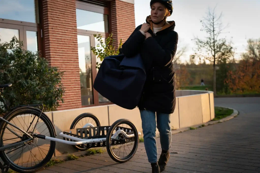 Frau trägt große Tasche vom Fahrradanhänger