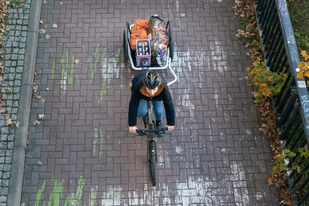 Fahrradfahrerin transportiert Einkauf mit Fahrradanhänger