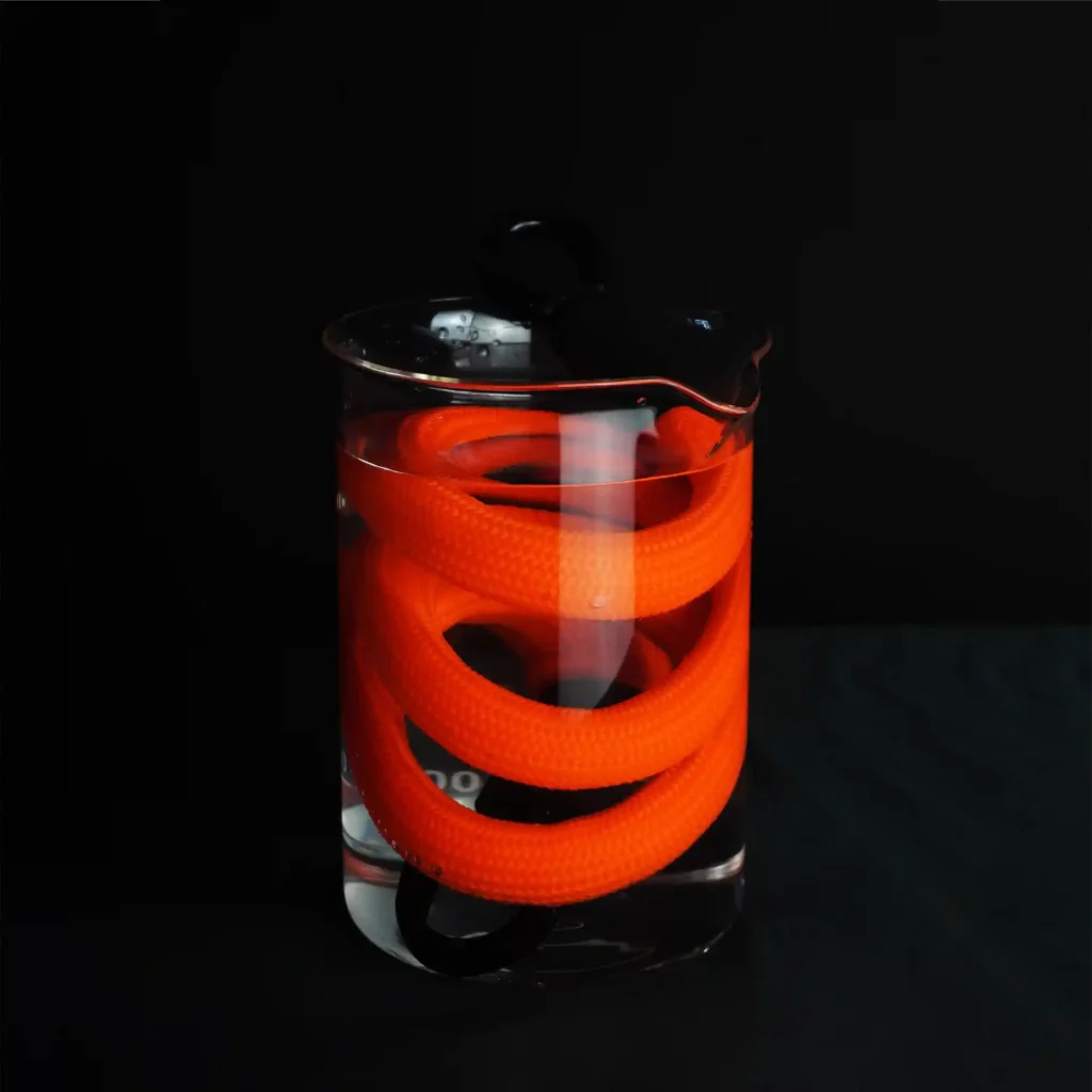 tex–lock acid orange Fahrradschloss im Glas mit Flüssigkeit