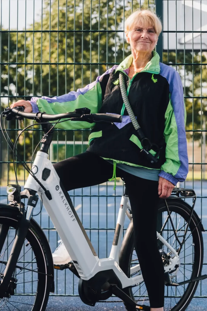 Sportliche Dame auf E-Bike mit tex–lock Special Edition 2024 um der Schulter