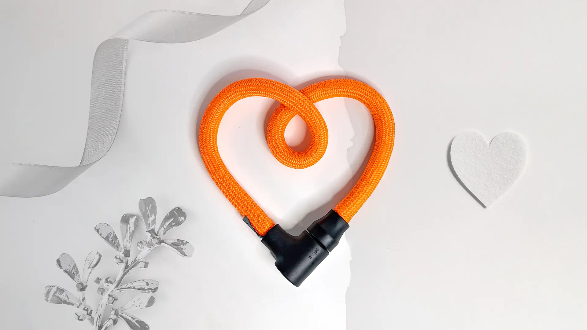 texlock orbit in acid orange als Geschenk für Radfahrer als Herz geformt vor weißem Hintergrund