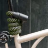 Schwarzes Fahrradschloss mit Neonmuster um Sattelstange von Brompton Faltrad gewickelt