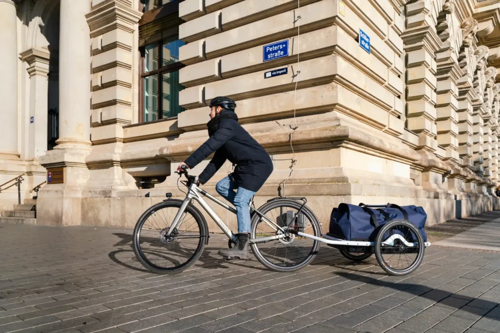 fahrradfahrerin mit fahrradanhänger in der stadt